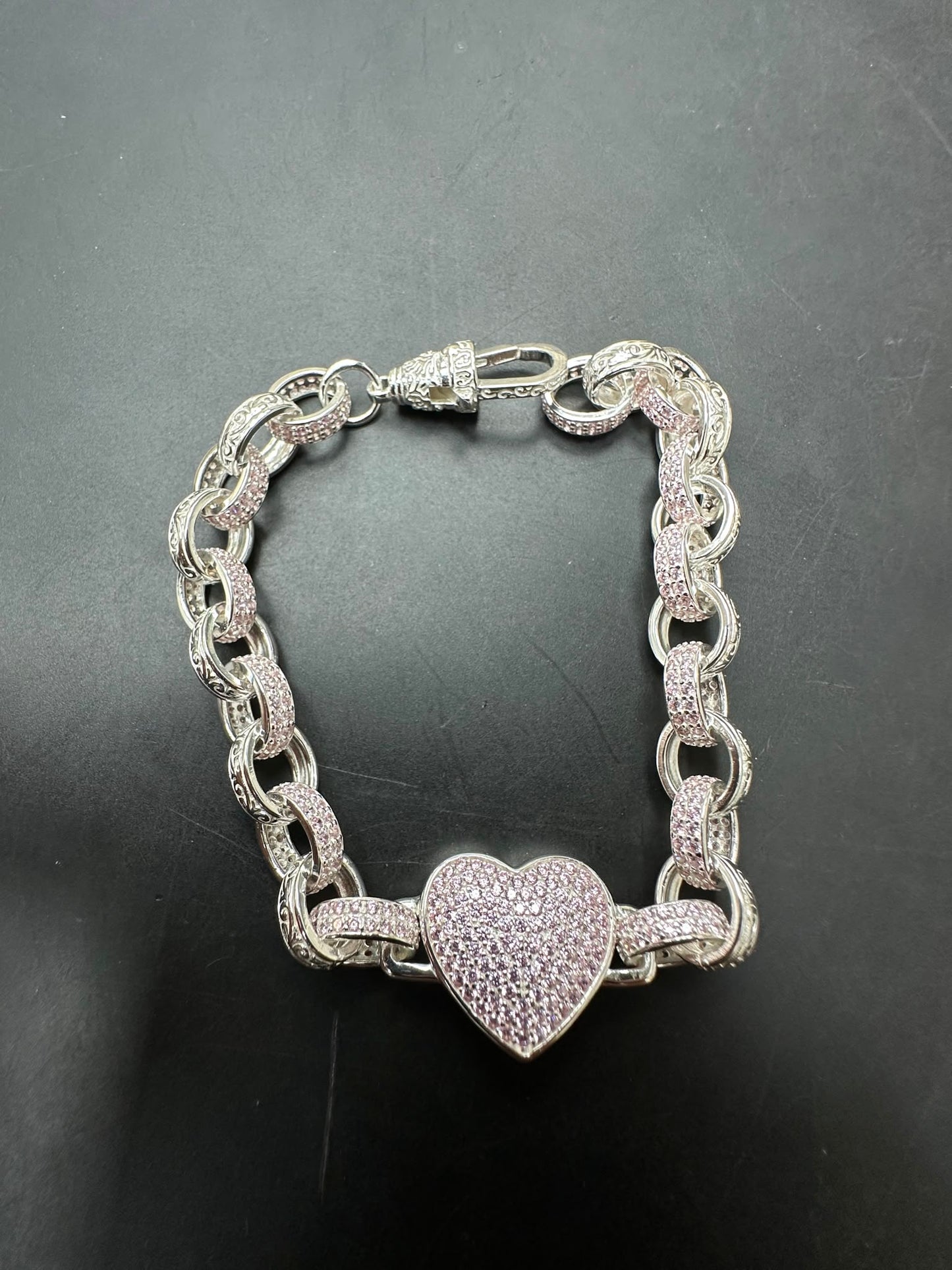 Sterling silver heart bracelet featuring a pink CZ pattern with a heart charm on a belcher chain.
