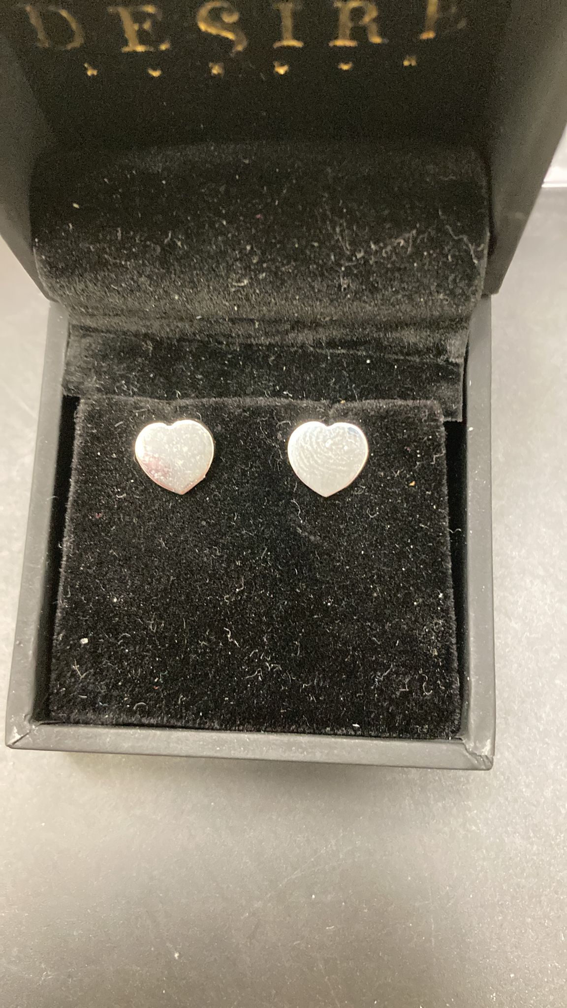 plain heart shape sterling silver stud earrings displayed in a black velvet box.