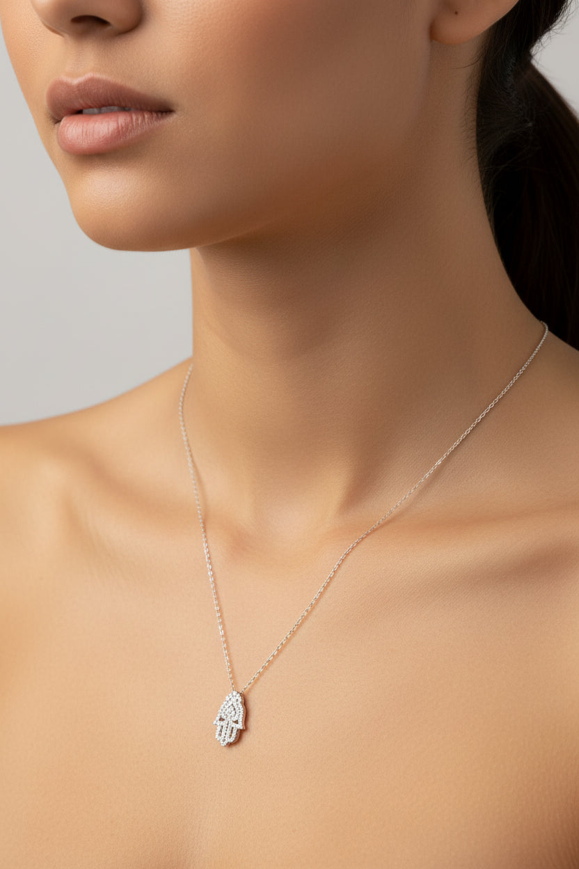Sterling silver hamsa hand necklace worn by a model, showcasing elegant design and craftsmanship.