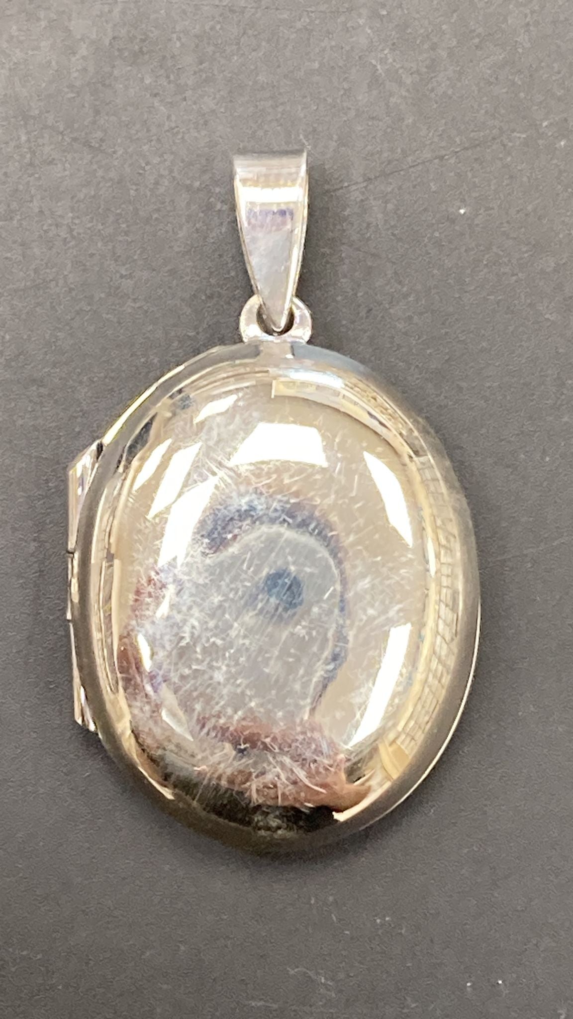 Sterling silver locked pendant PP210850021 showcasing a polished, oval design with a reflective surface.