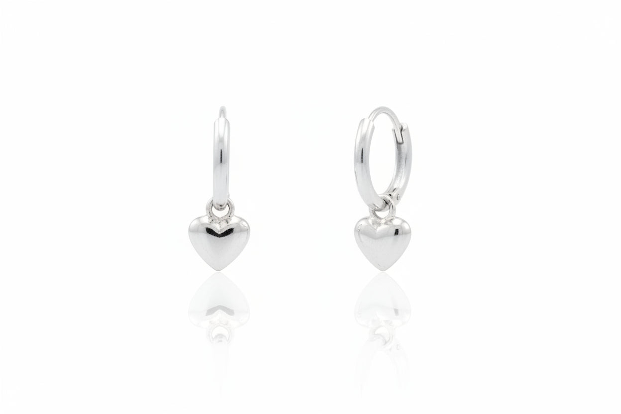 Sterling silver heart huggie earrings, featuring a drop heart design in a sleek and elegant style.