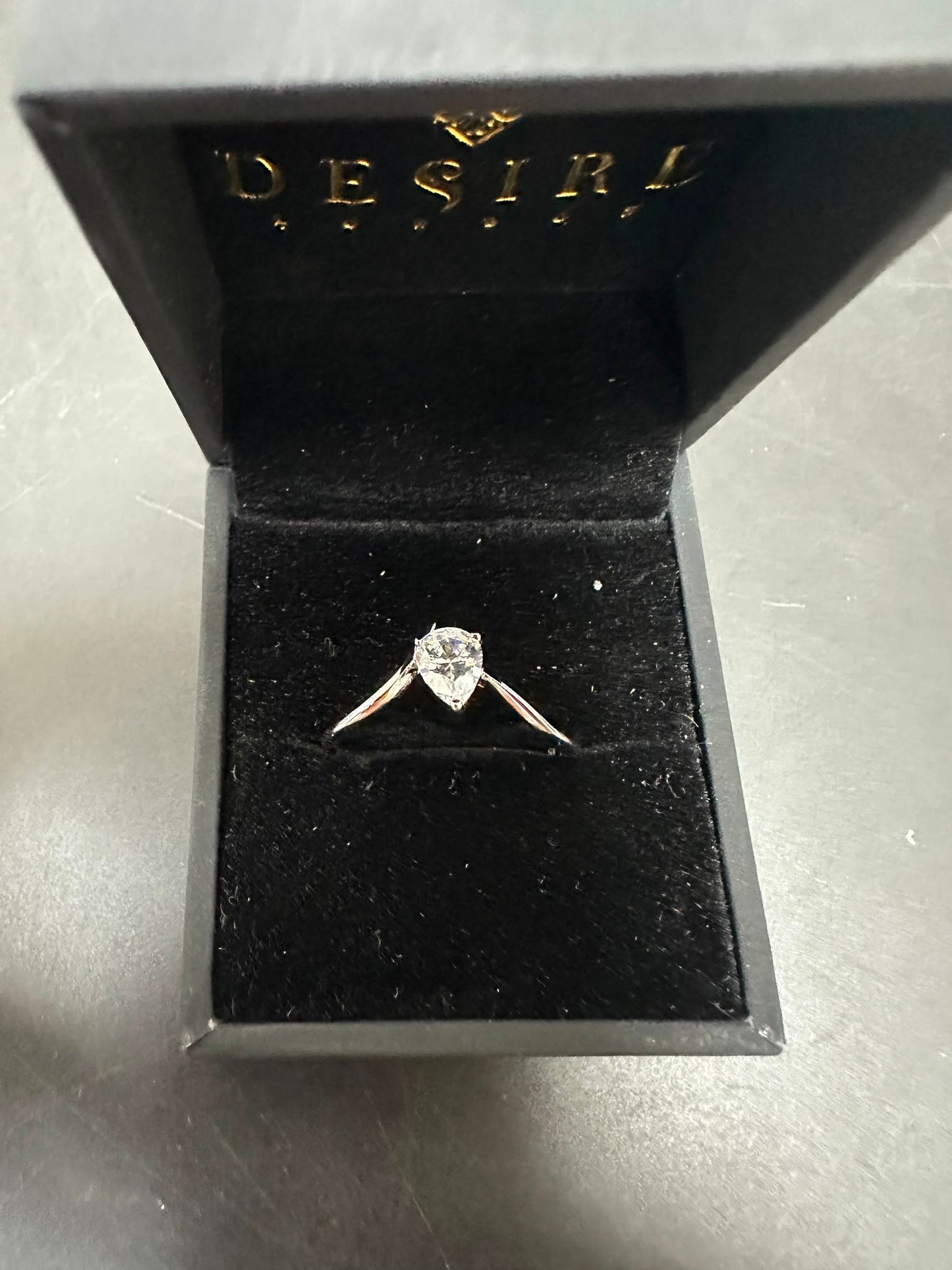 pear cut sterling silver ring with cz stone in a black jewelry box.