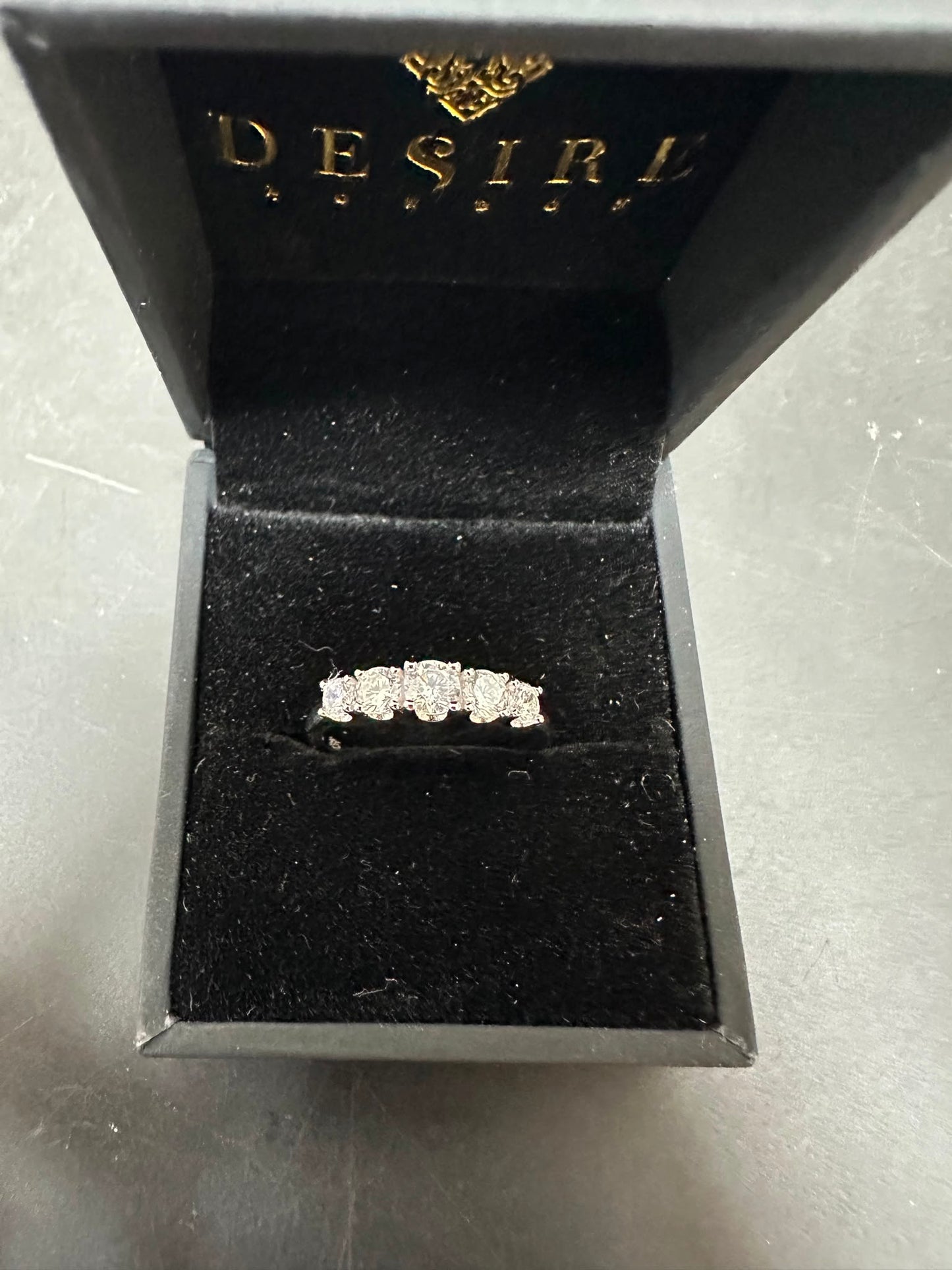 Sterling silver diamond cz stone ring displayed in a black jewel box with soft interior. Features five sparkling CZ stones.