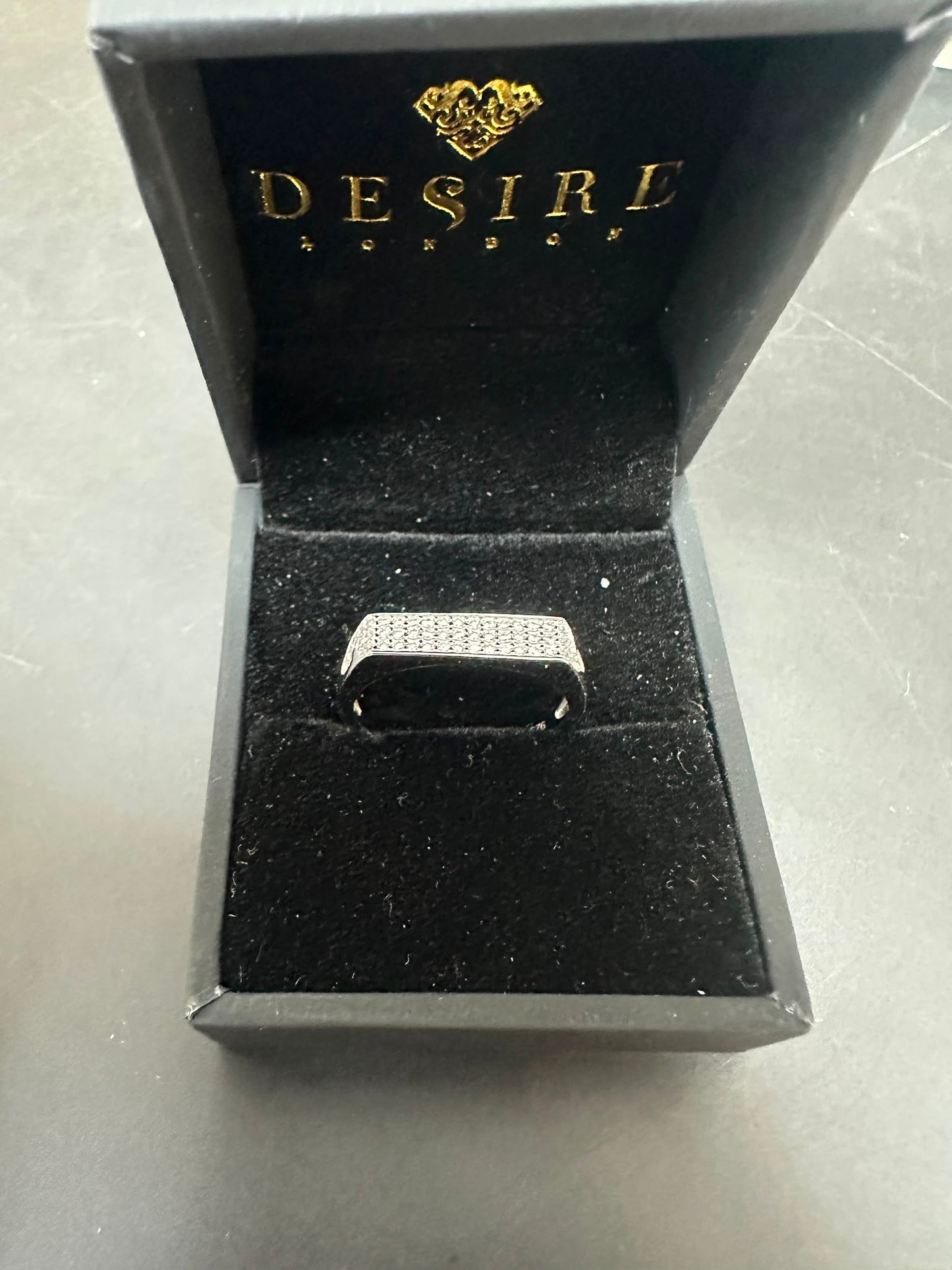 Sterling silver round cz ring displayed in an elegant black jewelry box from Desire London.