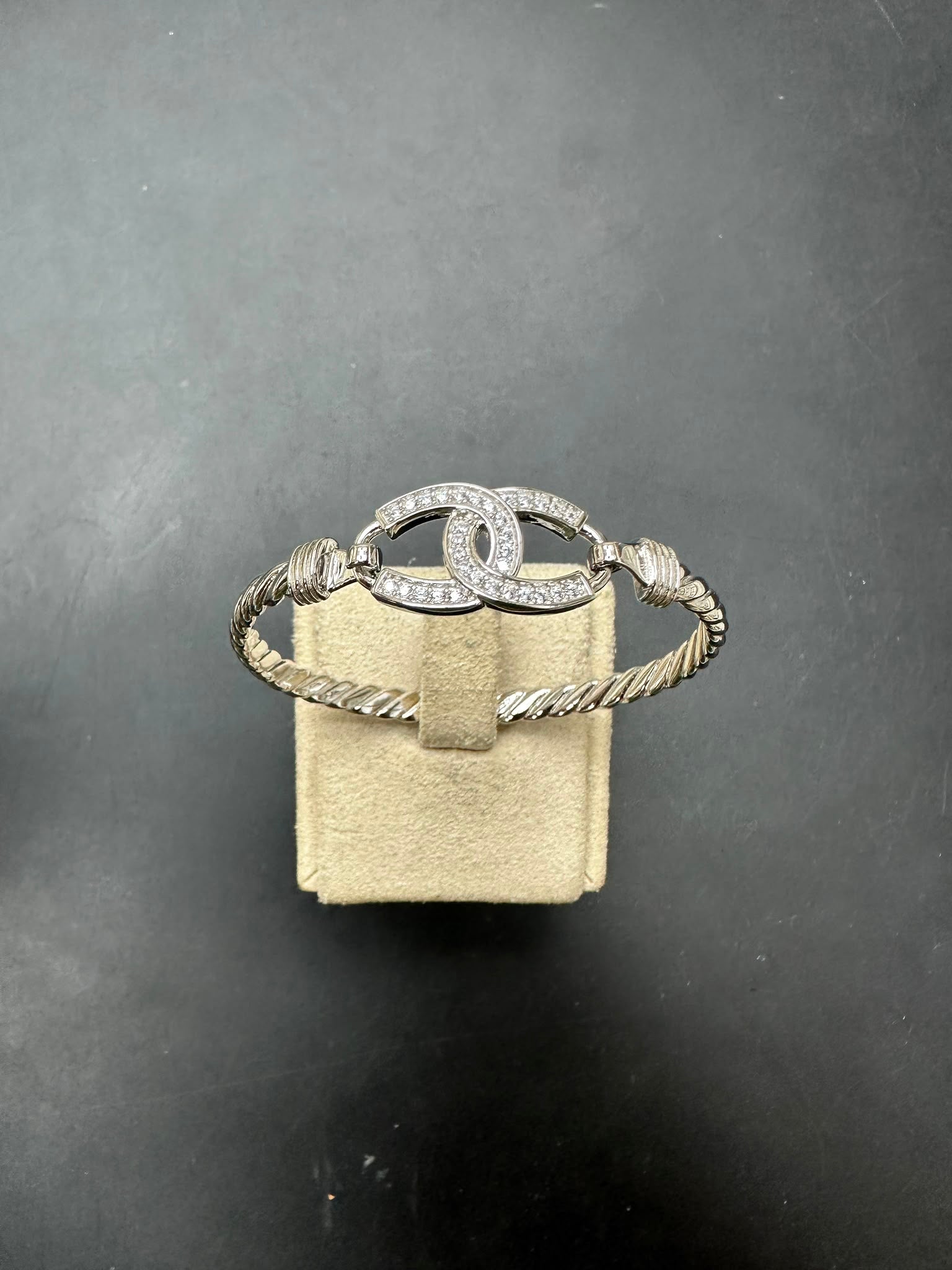 Sterling silver horse shoe bangle with CZ stones, white color, showcasing a sleek design and shimmering details.