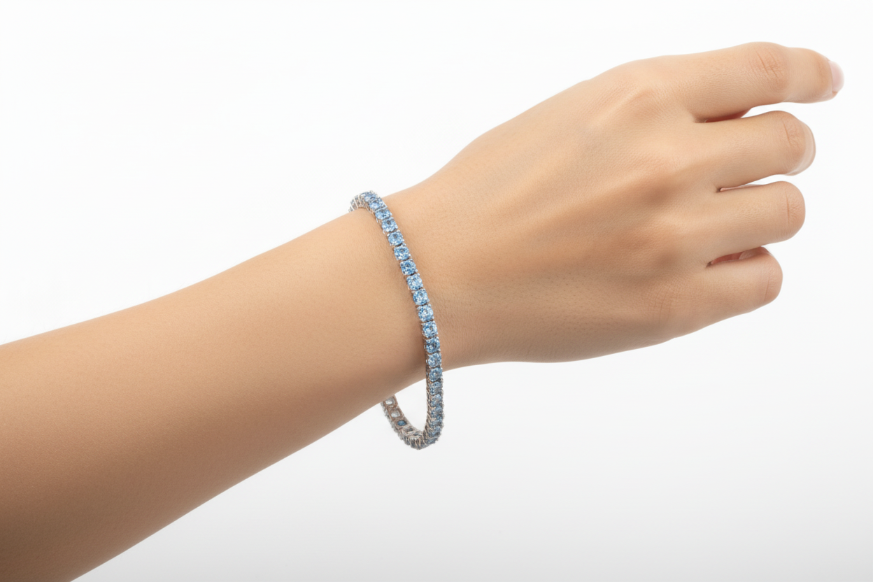 Hand wearing a blue beaded bracelet on a light gray background