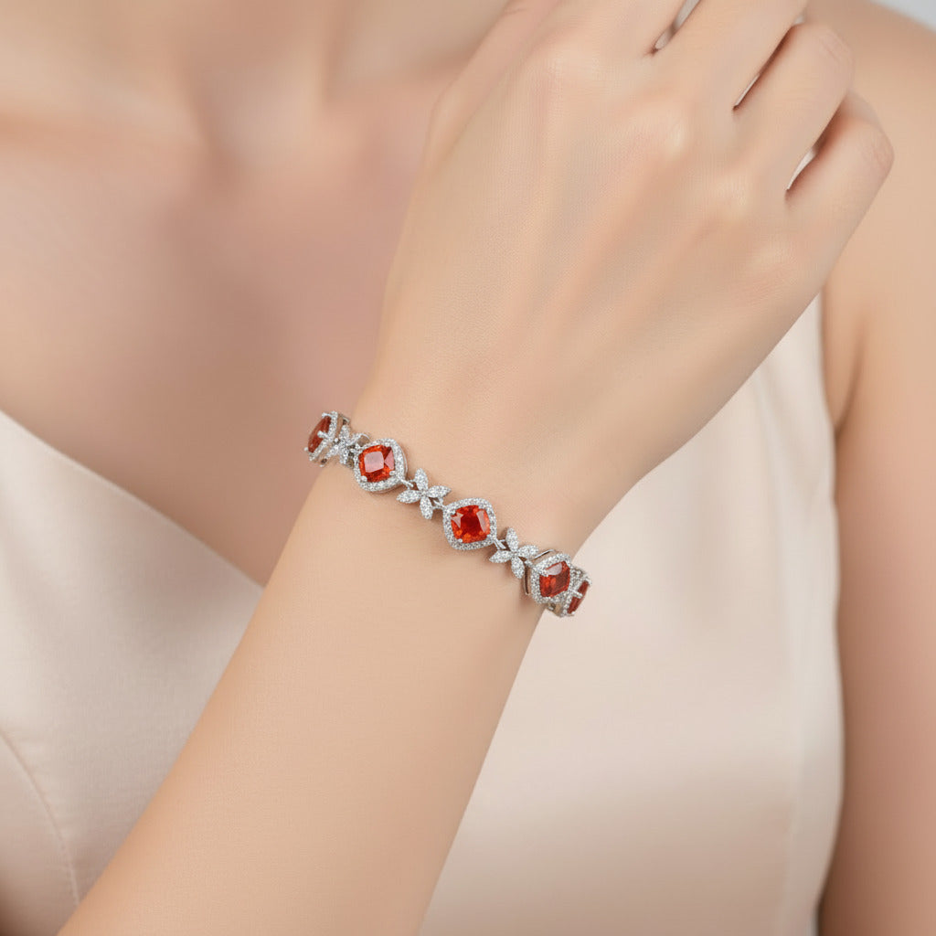 Silver bracelet with red gemstones on a white background