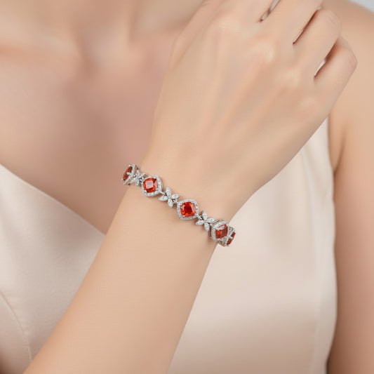 Silver bracelet with red gemstones on a white background
