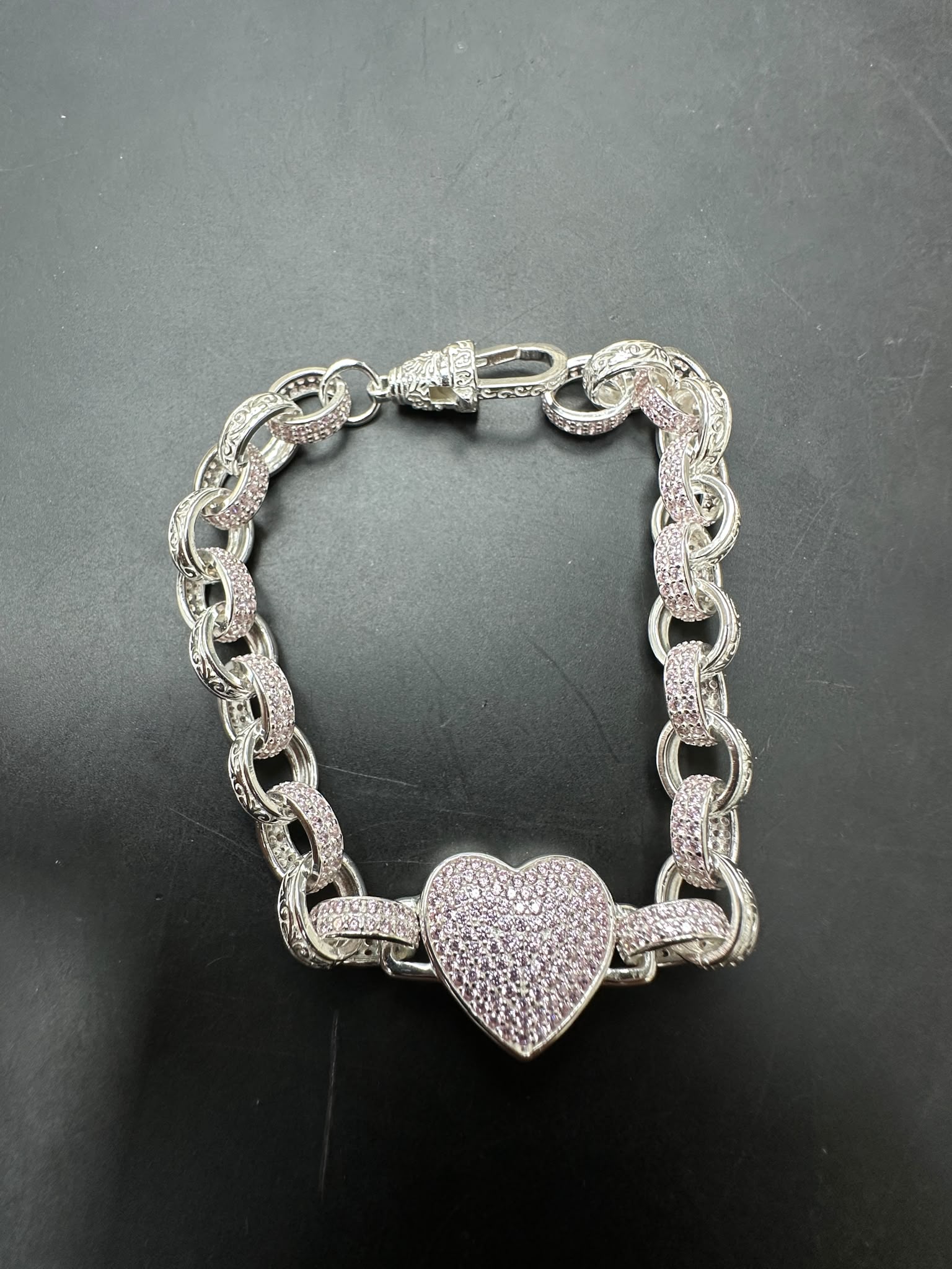 Sterling silver heart bracelet featuring a pink CZ pattern with a heart charm on a belcher chain.