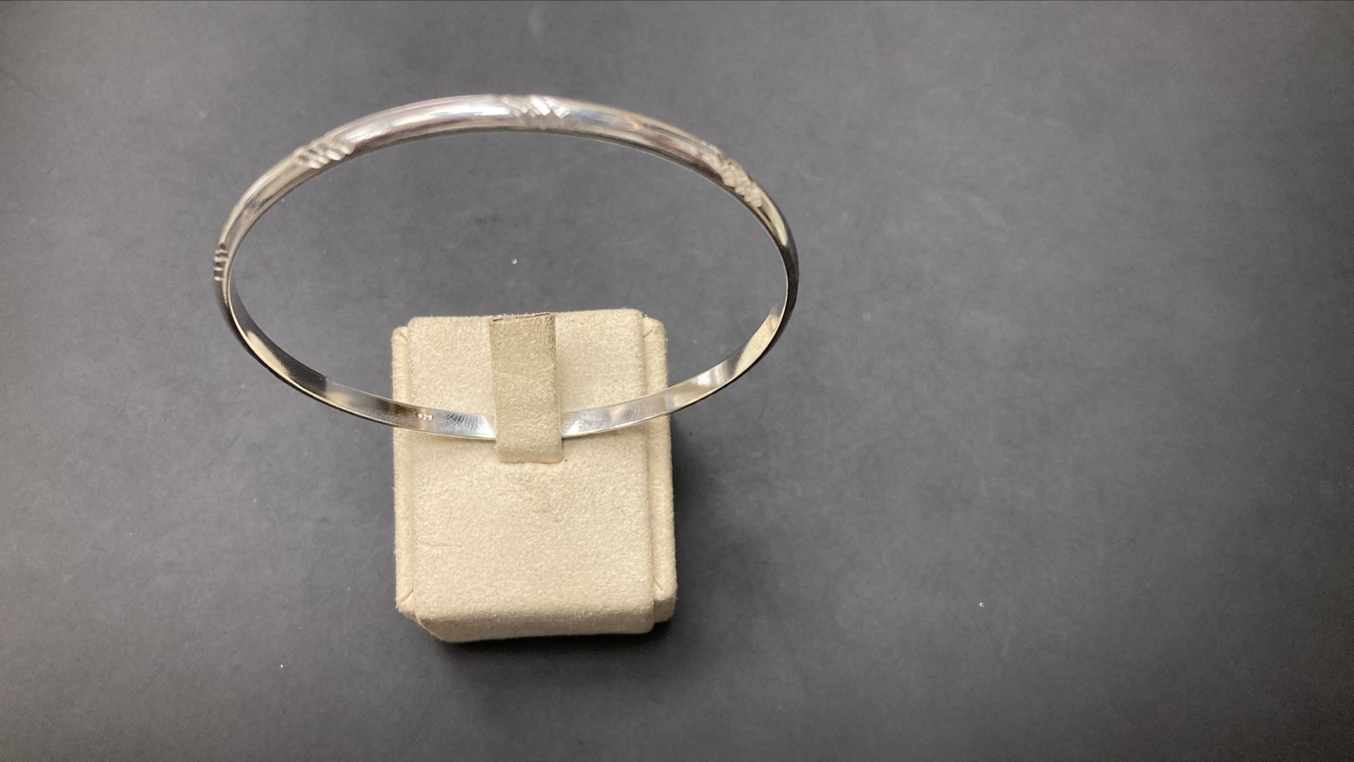 Sterling Silver Chevron Pattern Round Bangle BP10189 displayed on a jewelry stand, showcasing its elegant design.