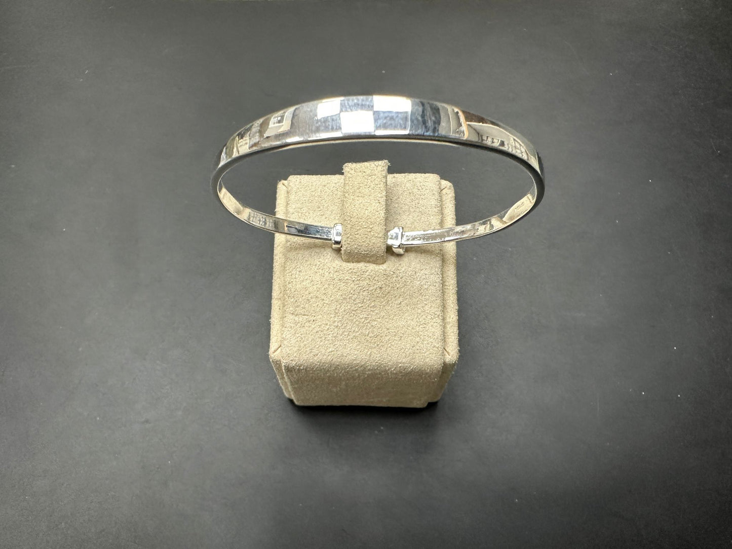 Sterling silver children's bangle displayed on a soft velvet stand, 6MM head thick and 55MM wide.