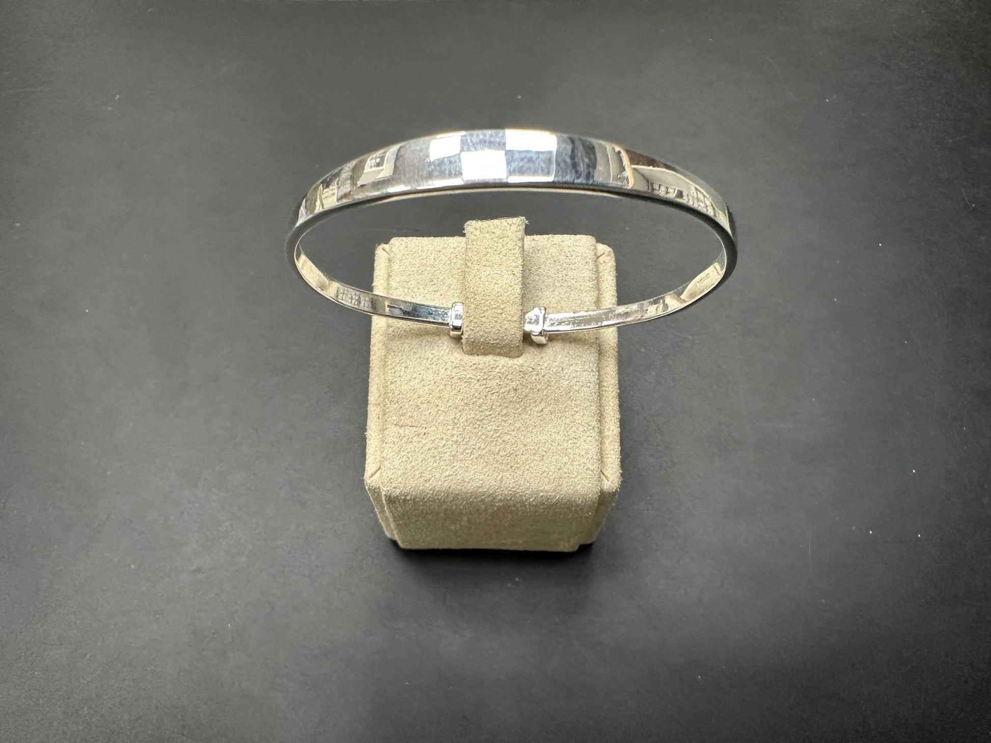 Sterling silver children's bangle displayed on a soft velvet stand, 6MM head thick and 55MM wide.