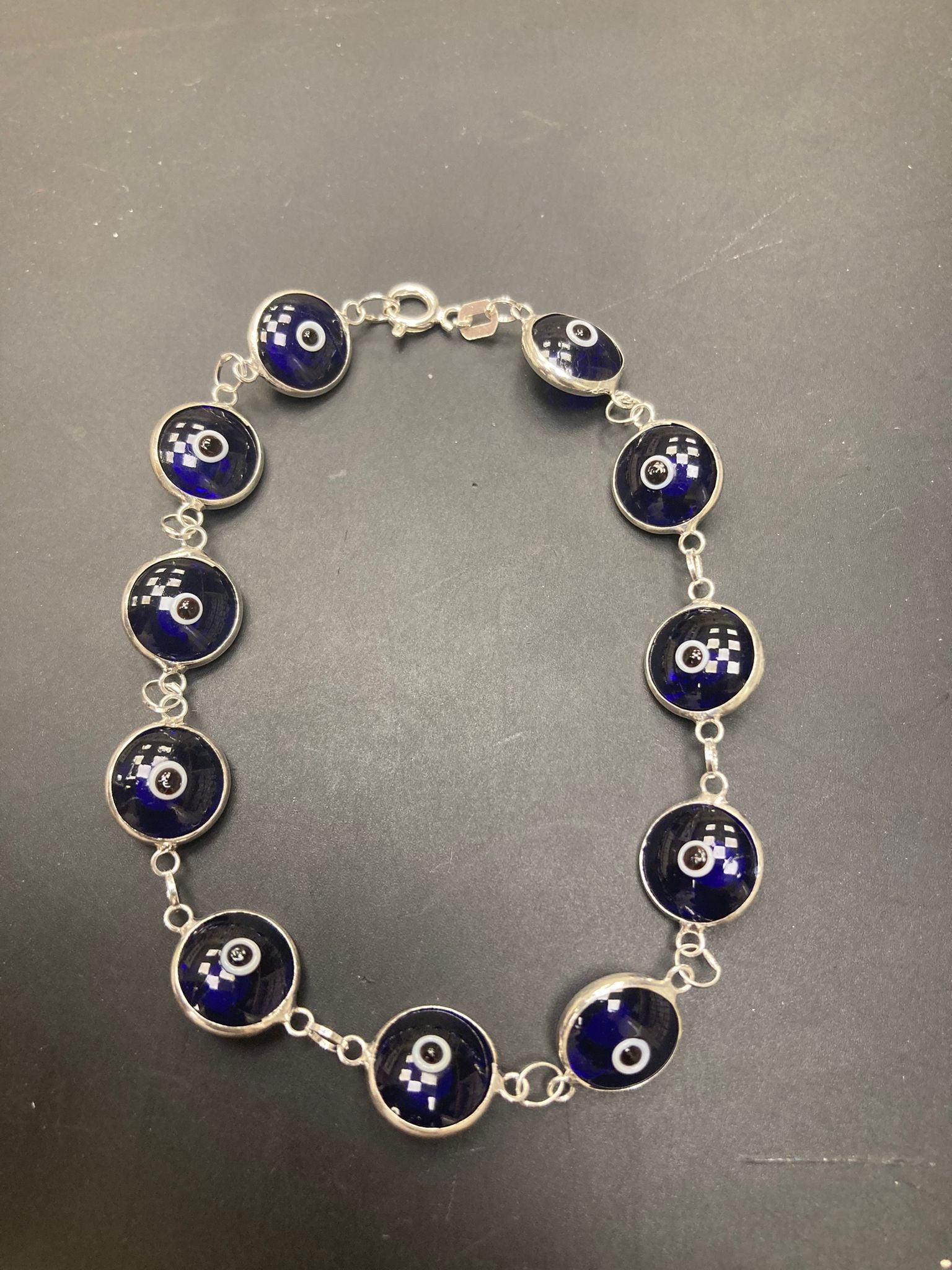 sterling silver evil eye bracelet featuring blue glass beads and intricate silver links