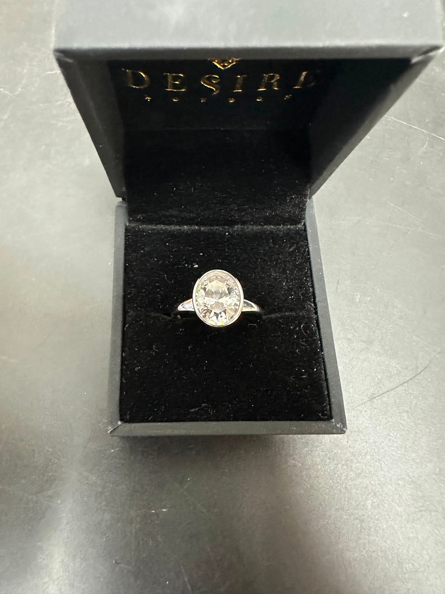 oval sterling silver ring with cz stone displayed in a black velvet box, featuring an 8x10mm center stone.