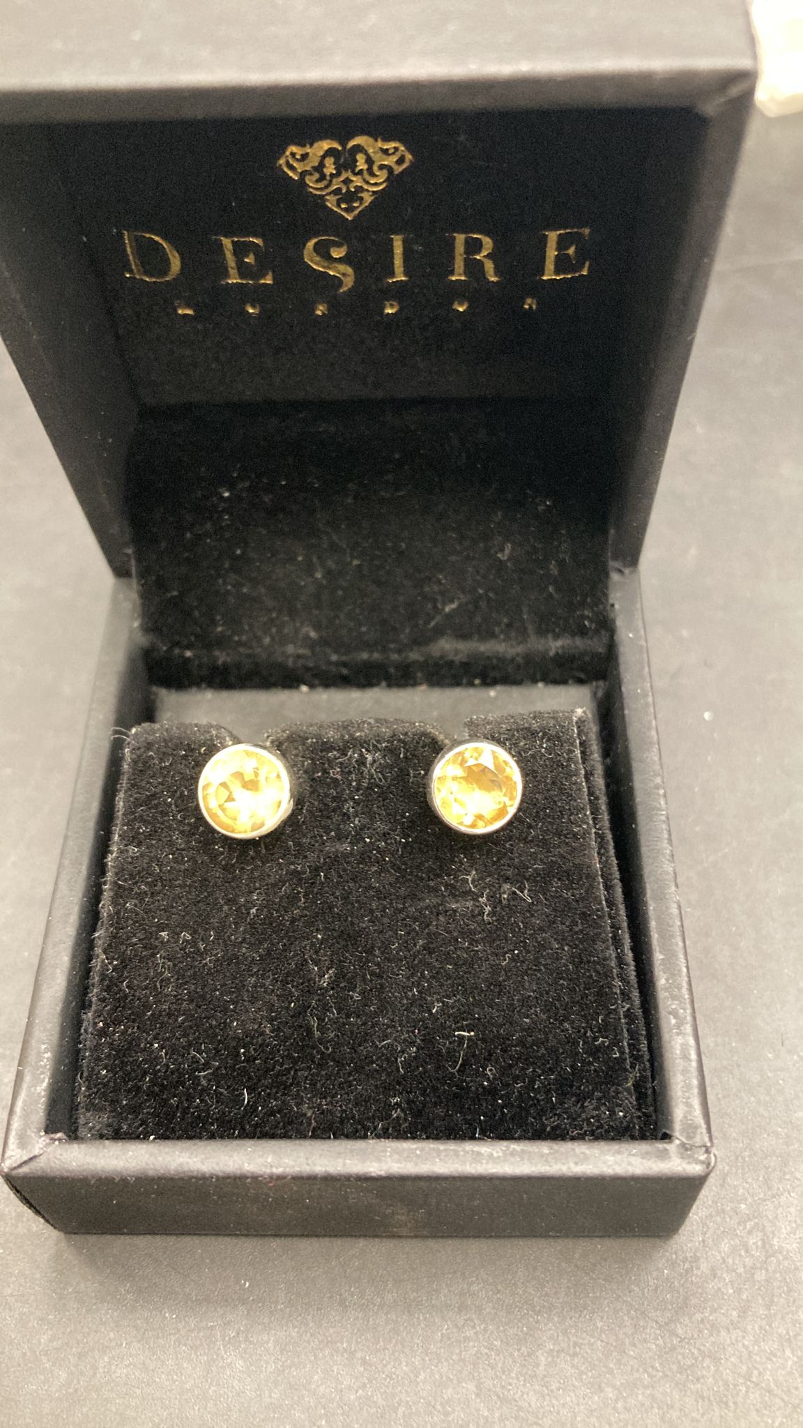 Sterling Silver Citrine Stone Stud earrings displayed in a jewelry box with a black velvet interior.