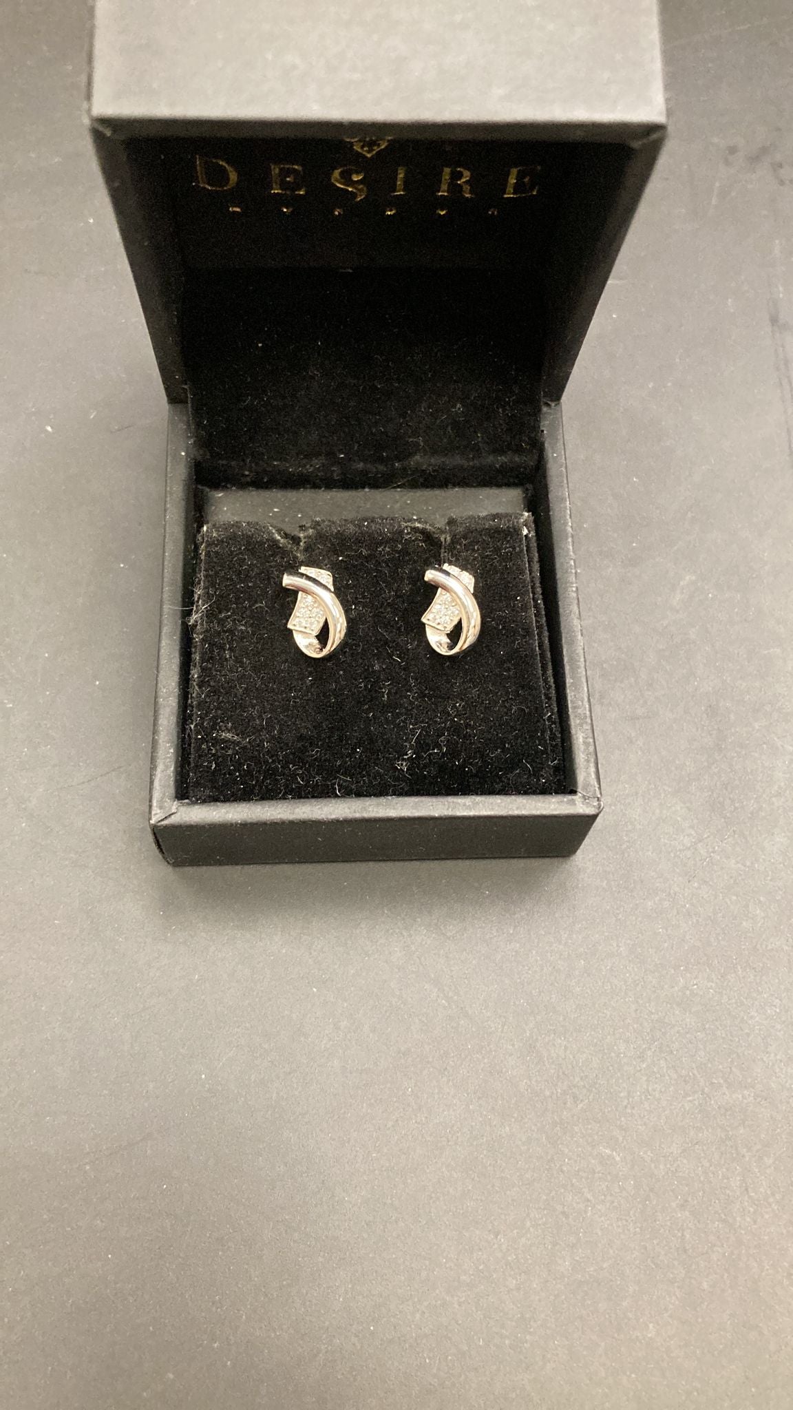 Sterling silver curved CZ earrings ECZ016 displayed in a black jewelry box for elegance and style.