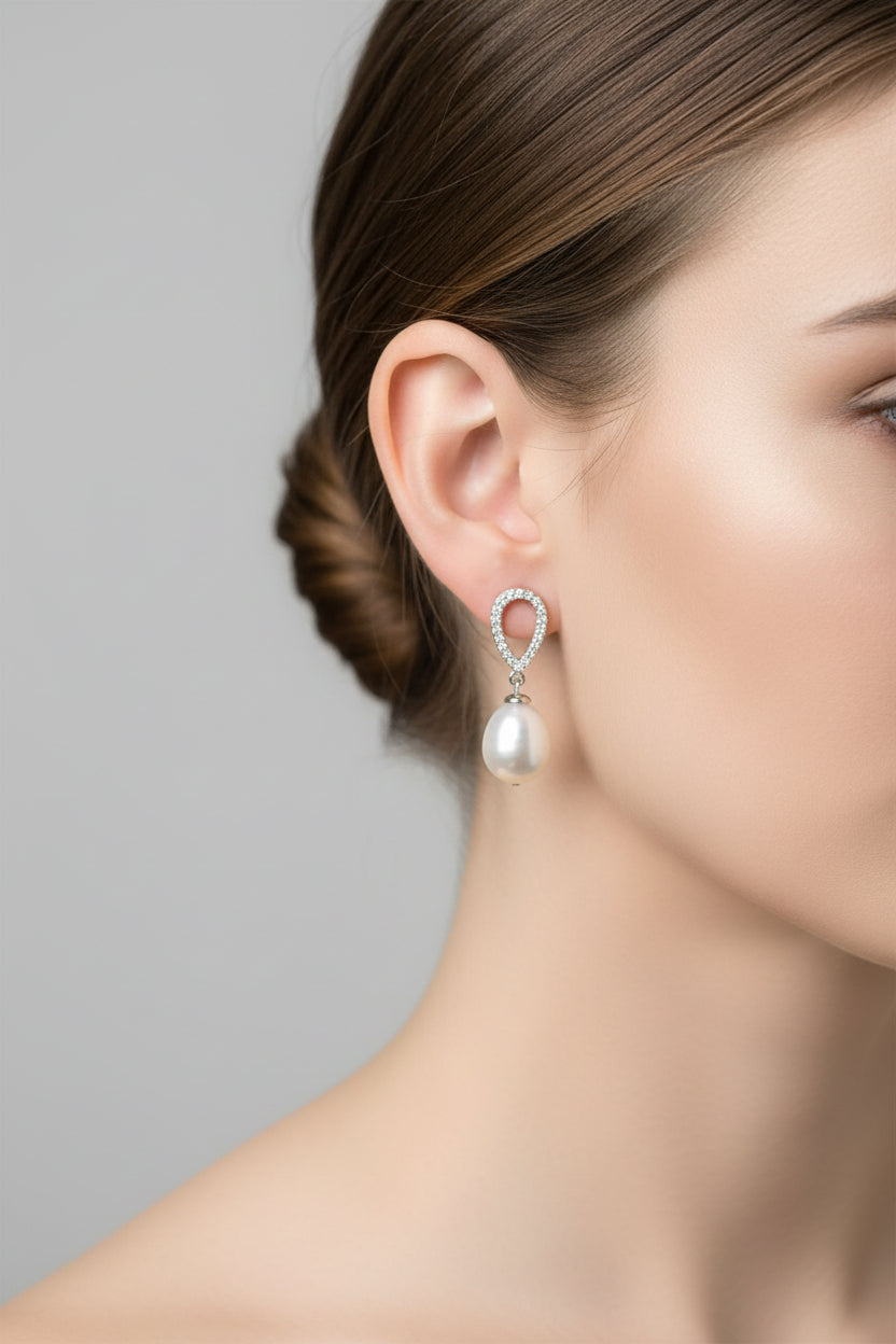 Sterling silver cz pearl earrings worn by a model, featuring a beautiful teardrop design.