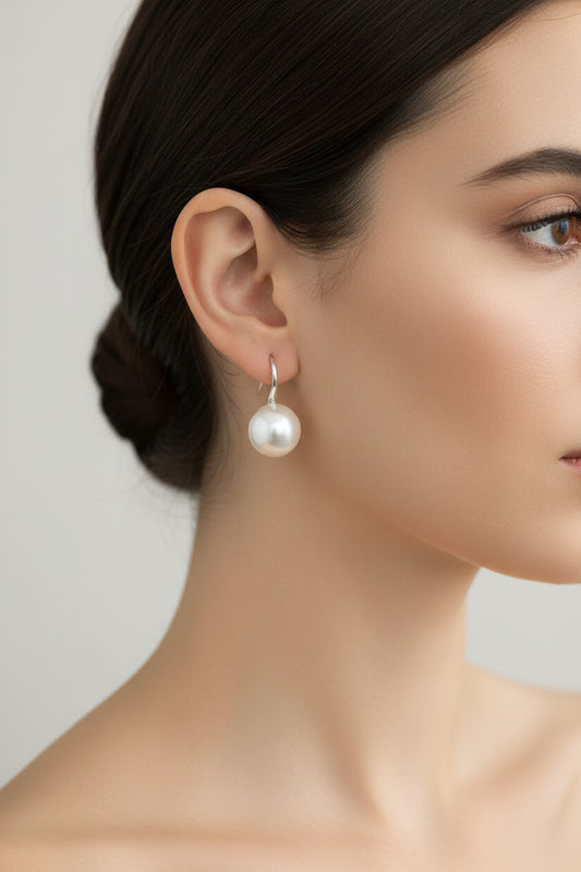 Sterling silver pearl earrings showcased on a model, highlighting their elegant design and lustrous pearls.