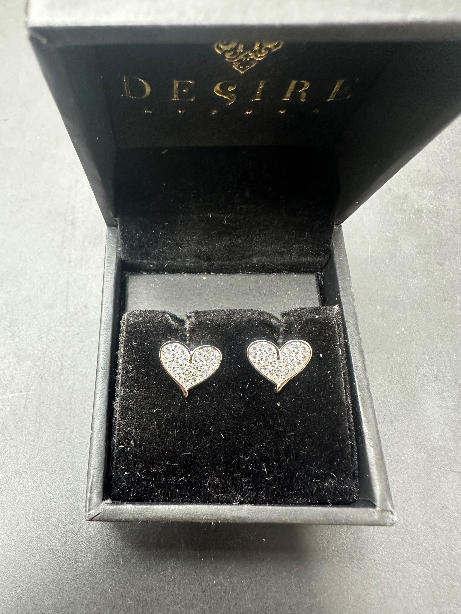 Sterling silver heart cz earrings displayed in a velvet black box with the word 'Desire' visible.