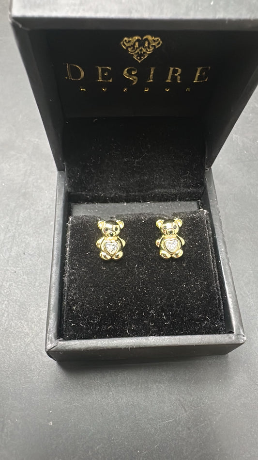 Sterling silver bear studs with CZ stones displayed in a Desire London box, featuring gold plating.