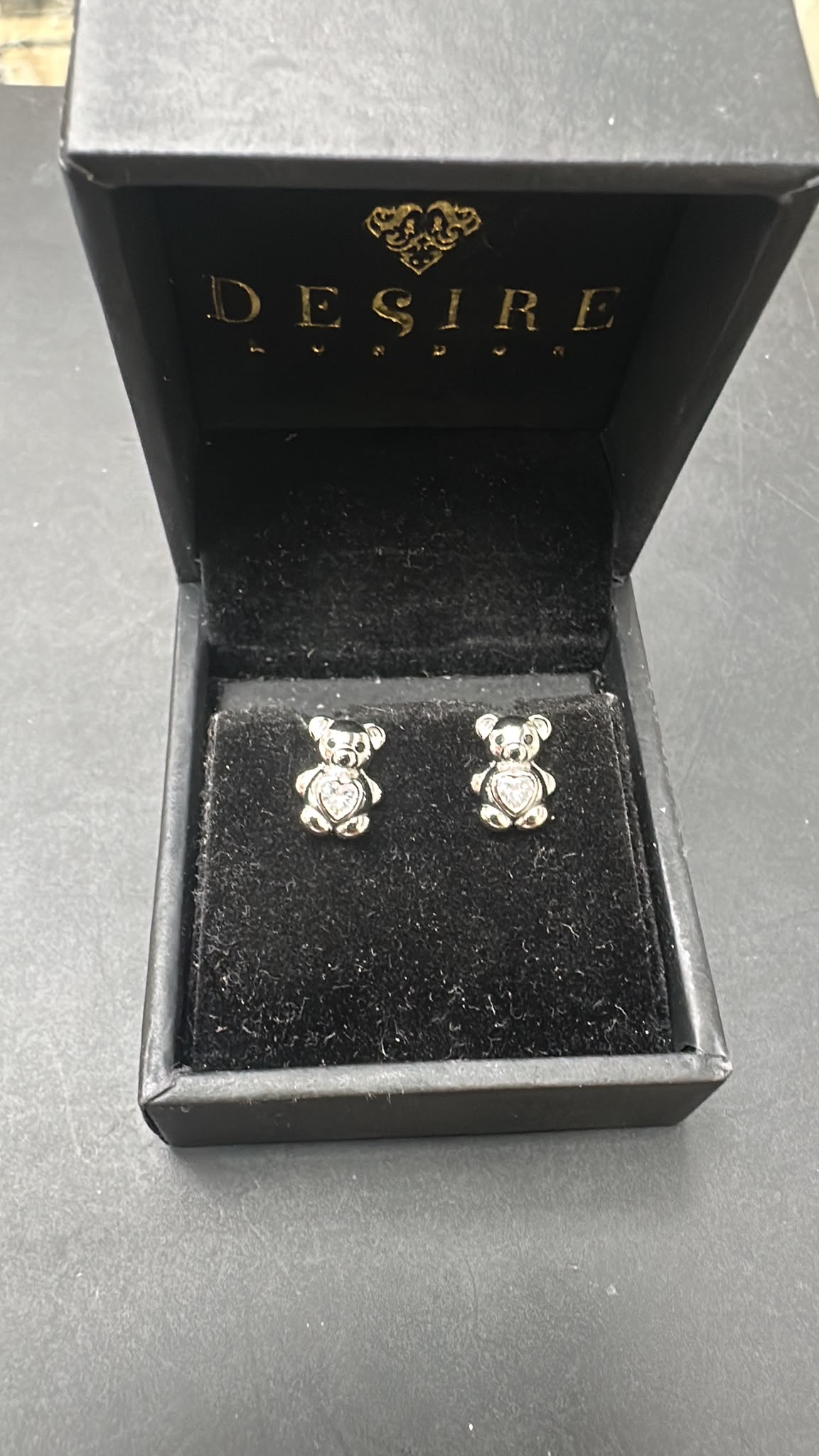 Sterling silver bear studs with CZ stone displayed in a black jewelry box.