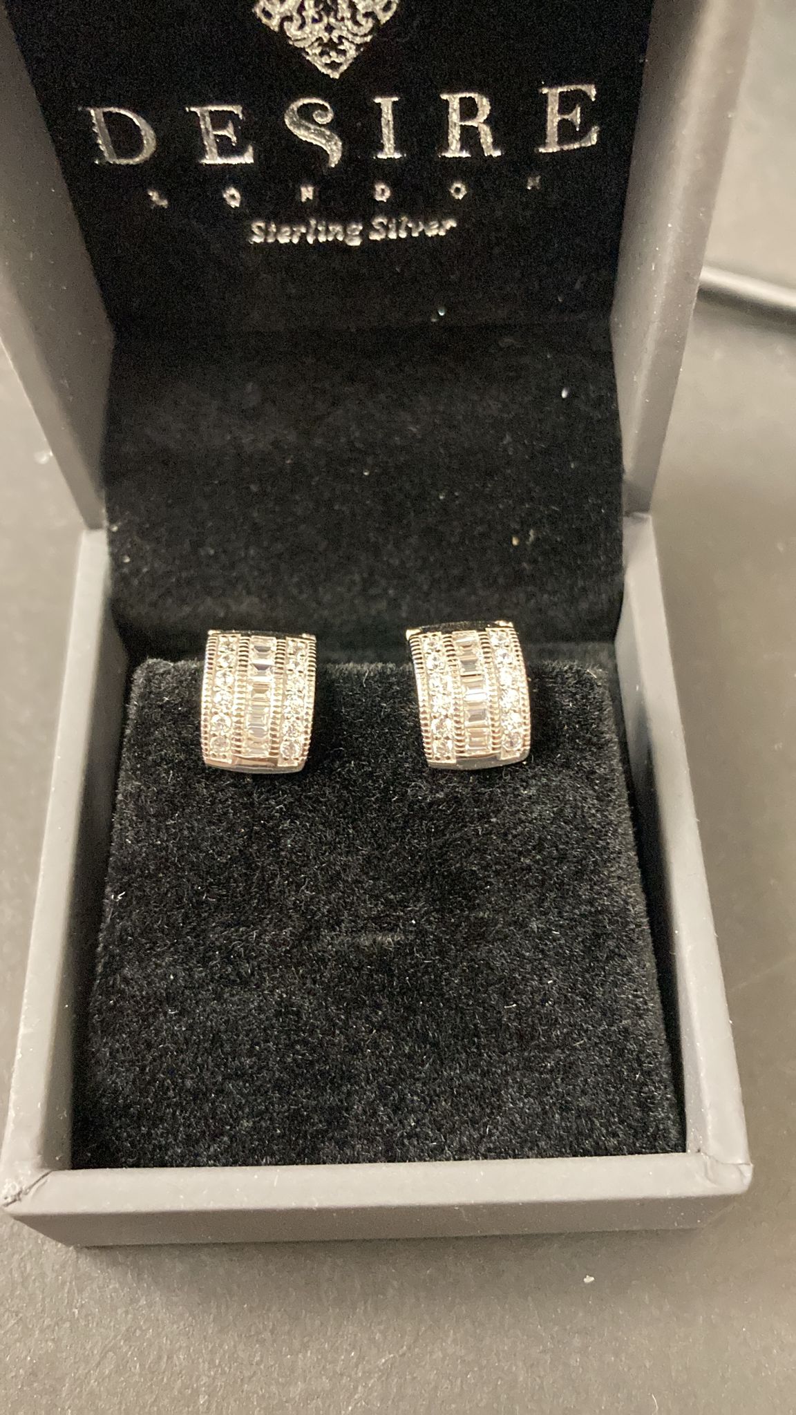 Sterling Silver Cz Huggies ECZ3037 displayed in a box, featuring sterling silver cz huggie earrings.