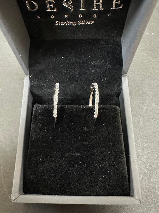 Sterling Silver Cz Hoop Earrings displayed elegantly in a black velvet box, emphasizing their sparkle and quality.