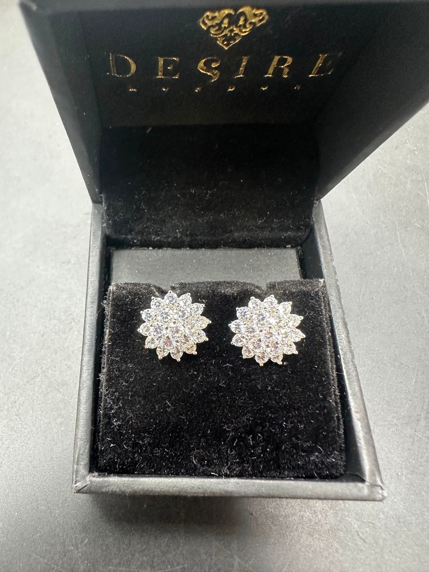 Sterling silver studs with cz stone displayed in a black jewelry box with velvet interior.