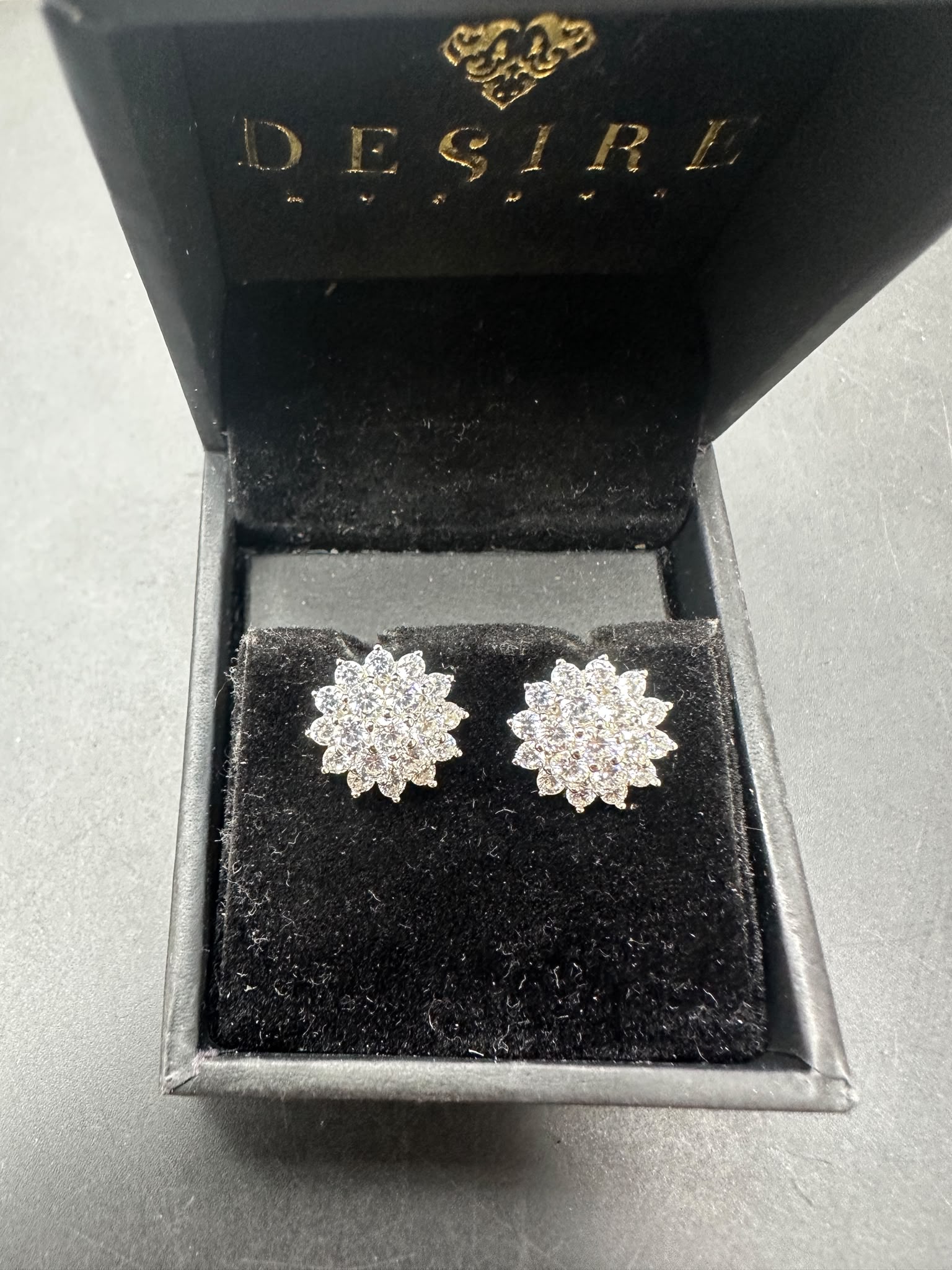 Sterling silver studs with cz stone displayed in a black jewelry box with velvet interior.