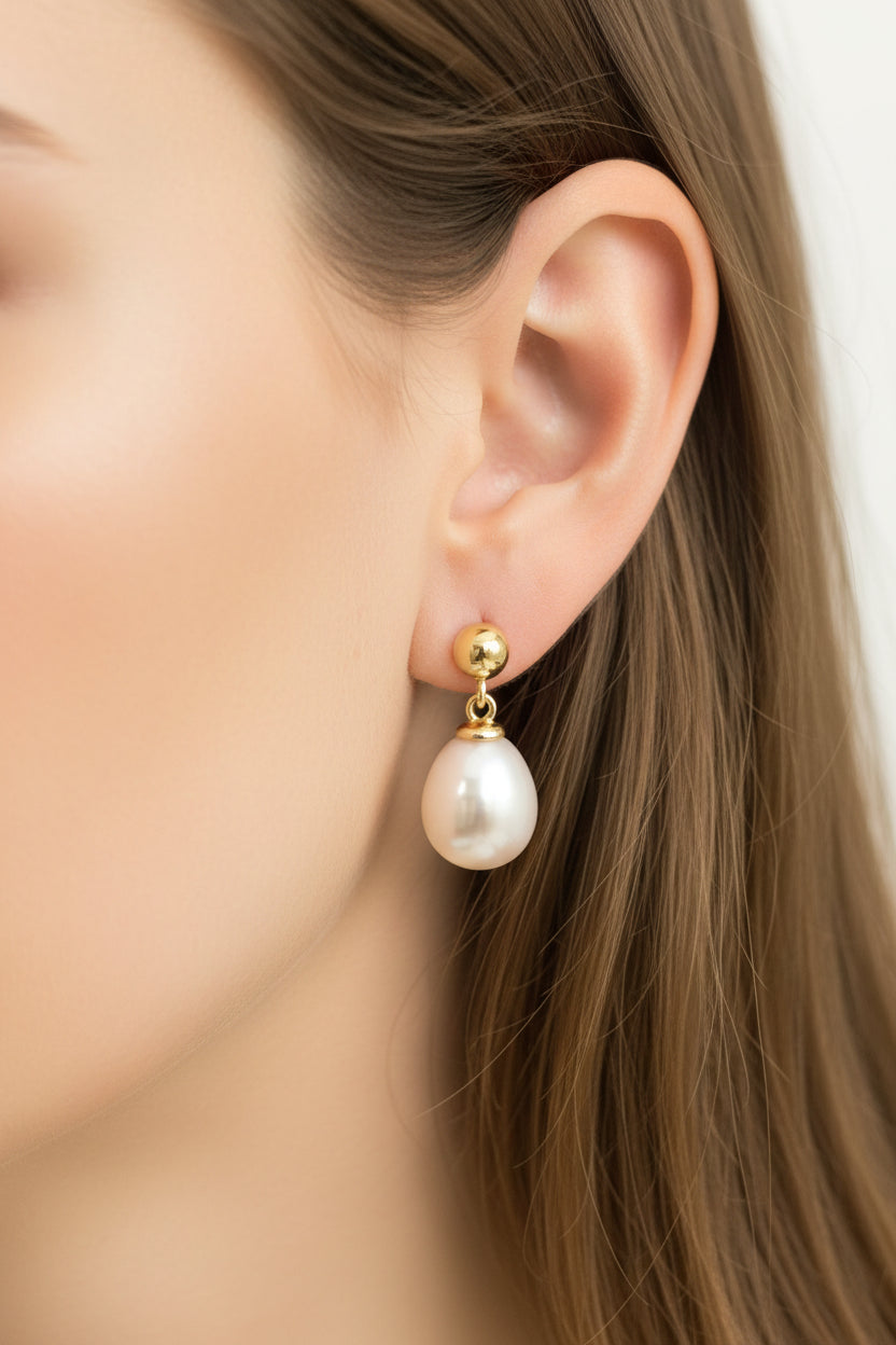 Close-up of a model wearing sterling silver teardrop pearl earrings ECZ8710 with a classic gold setting.