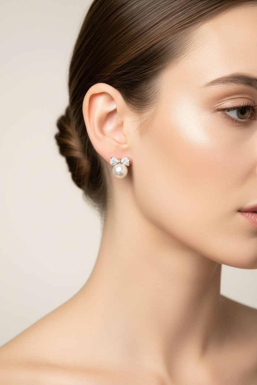 Close-up of a model wearing sterling silver cz bow pearl studs, showcasing elegance and sophistication.