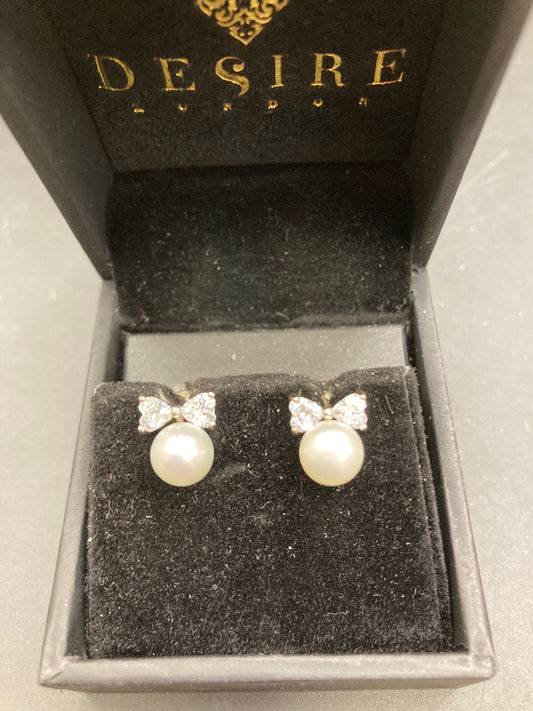 Sterling Silver Cz Bow Pearl Studs in a luxurious Desire London box on a black velvet background.