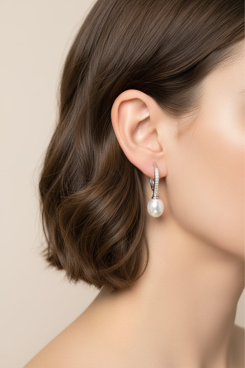 Sterling silver pearl earrings worn by a woman with a sleek bob haircut, featuring cz leverback design.