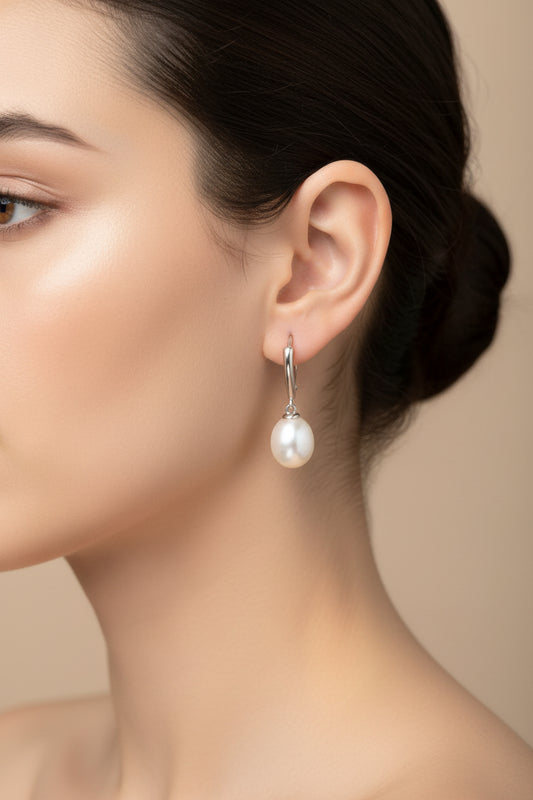 Model showcasing sterling silver leverback pearl earrings, featuring a classic design with lustrous pearls.