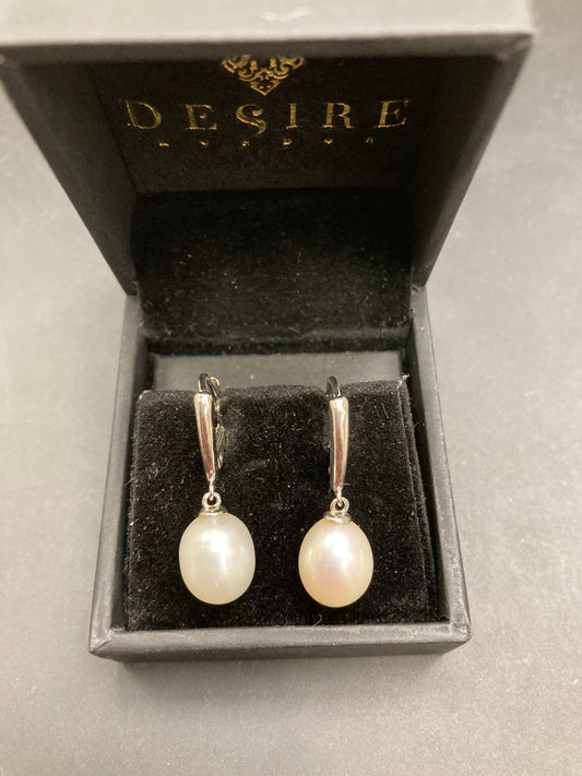 Sterling silver leverback pearl earrings displayed in a black box with the logo Desire.