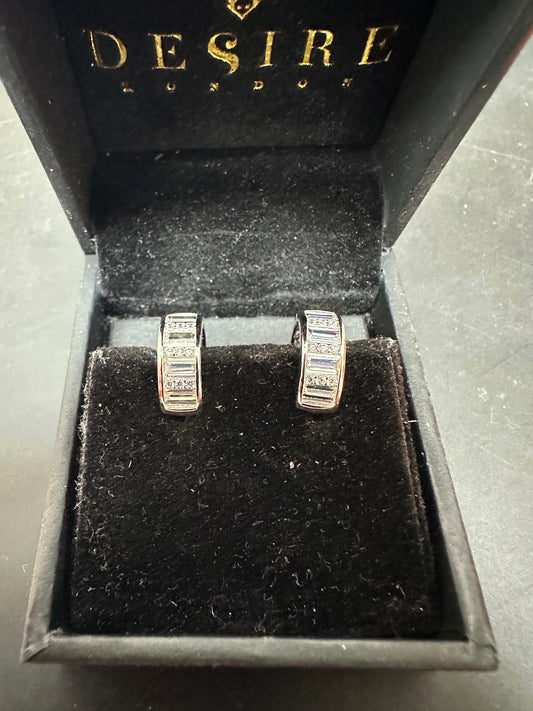Sterling silver huggie earrings with cz stones displayed in a black jewelry box from Desire London.