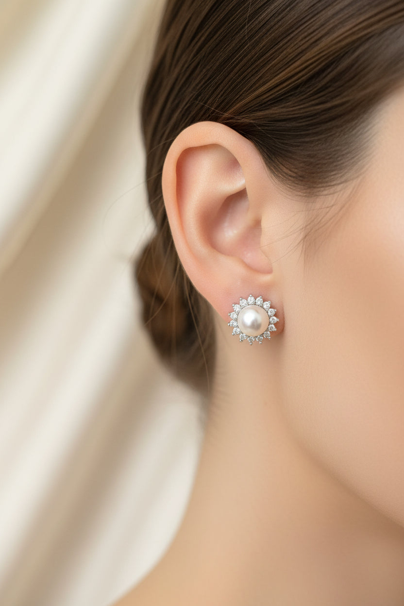 Close-up of a model wearing sterling silver pearl stud earrings with cubic zirconia accents.