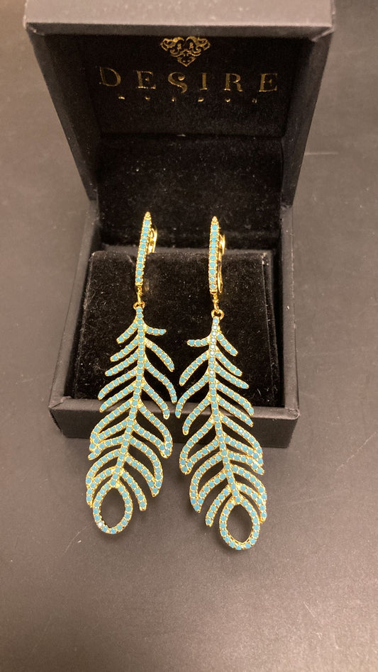 Sterling silver feather earrings displayed in a jewelry box, featuring intricate feather design and blue accents.