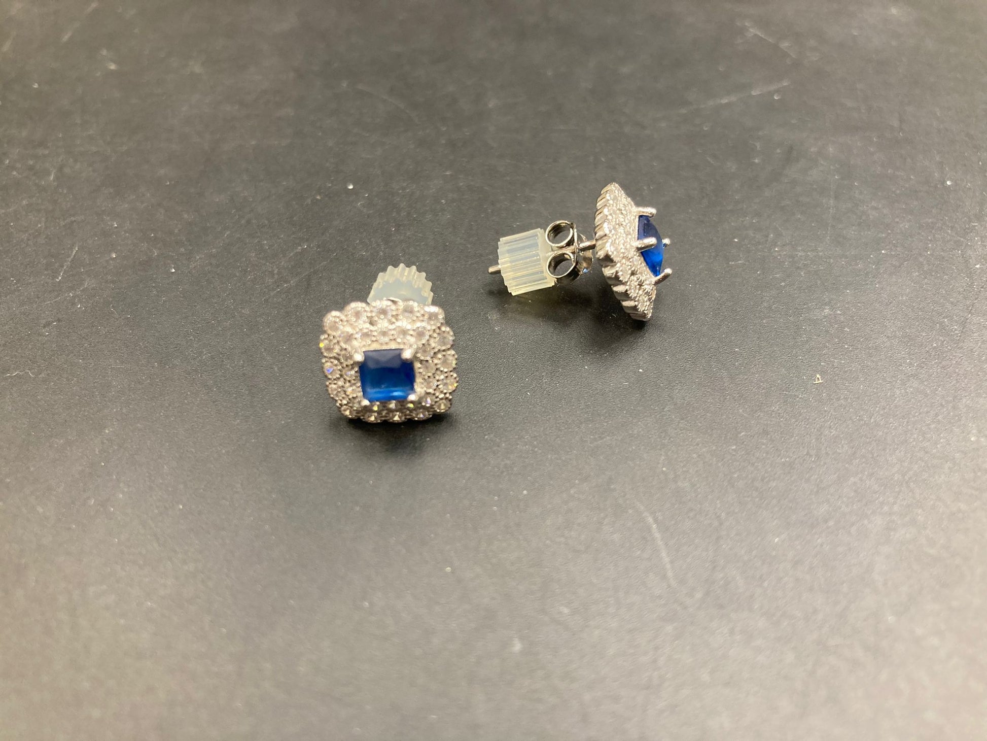 Sterling silver cz stud earrings featuring blue gemstones and a sparkling design.