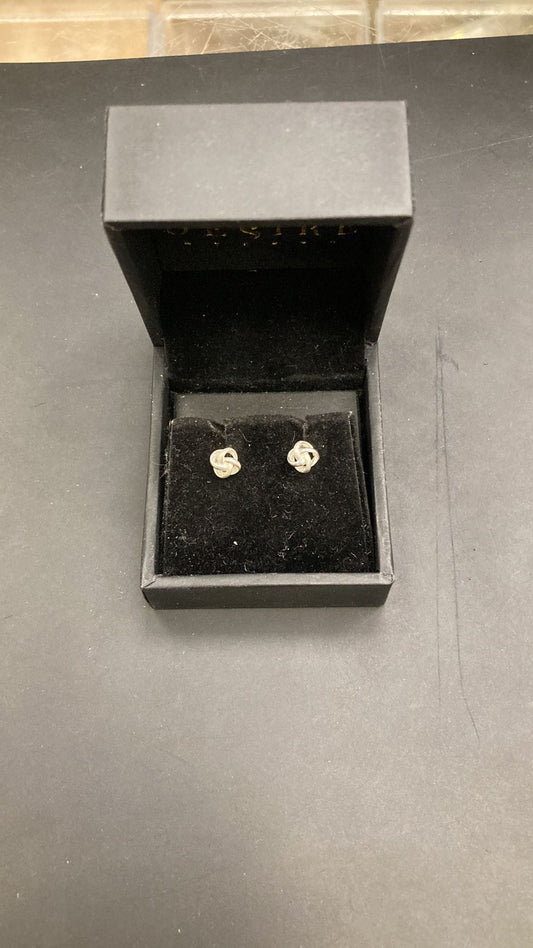 Sterling silver knot stud earrings displayed in a black jewelry box.