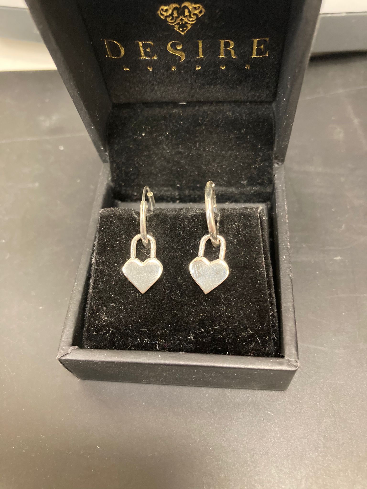 Sterling Silver Heart Dangle Earrings EP0012 displayed in a black jewelry box with a soft lining.
