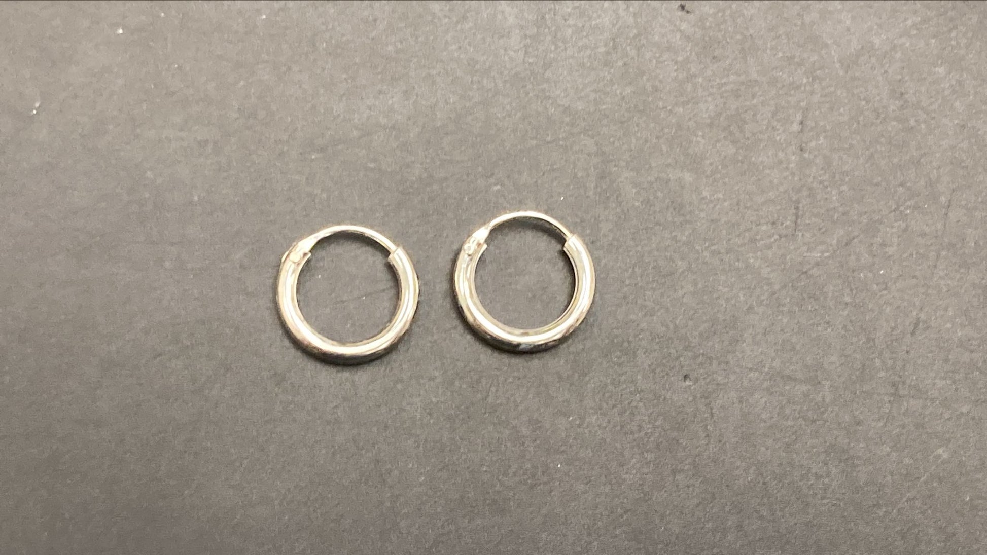 Sterling Silver Round Hoop Earring EP010340233, stylish sterling silver round hoop earrings on a black background.