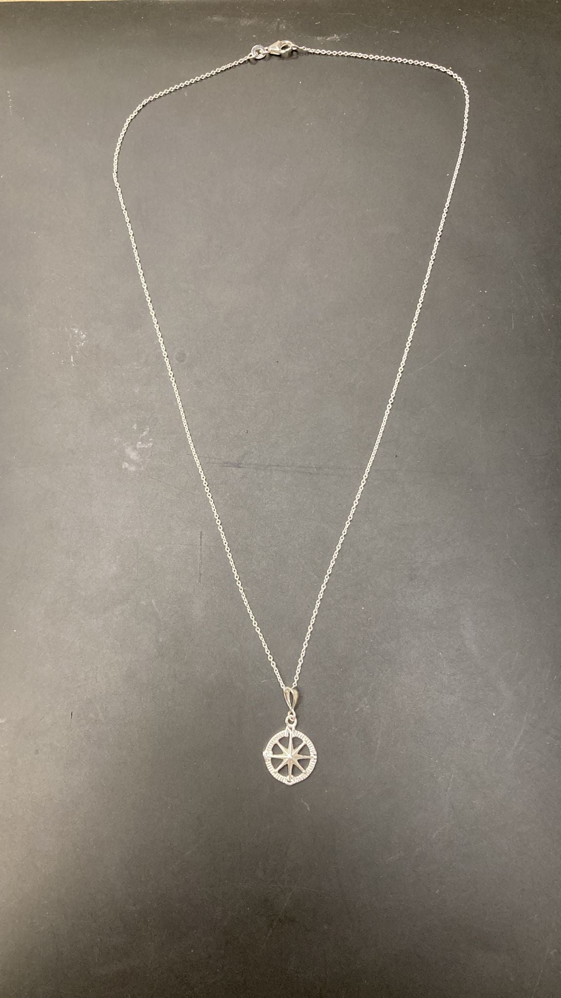 Sterling silver compass necklace NP10208 displayed on a black background.