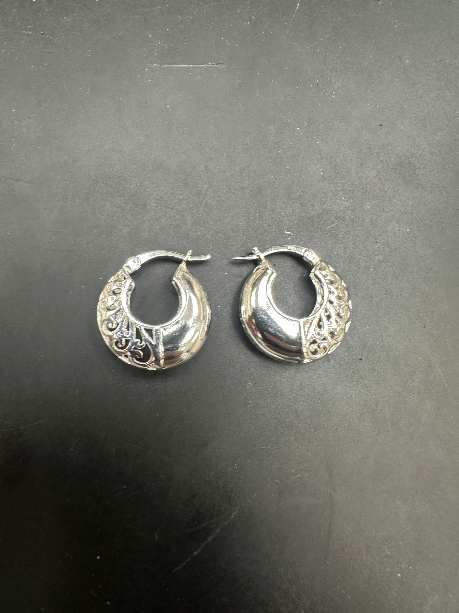 Sterling Silver Patterned Hoop Earrings EP10245 showcased on a black background, highlighting their intricate design.