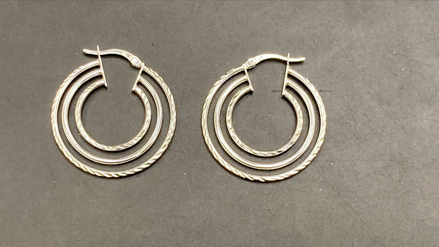 Sterling silver round hoop earrings, featuring a layered design with twisted details and a polished finish.