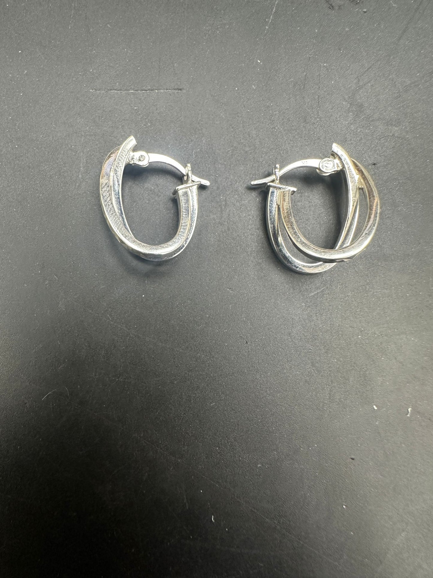 Sterling Silver Earrings EP117 displayed on a dark surface, showcasing their elegant design and shine.