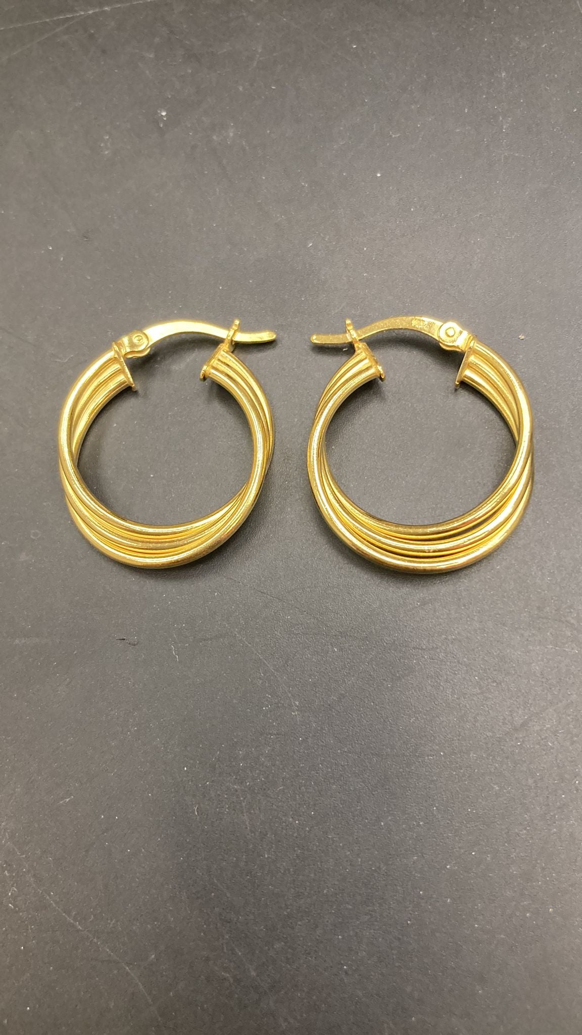 A pair of elegant sterling silver huggies earrings with a unique pattern design.