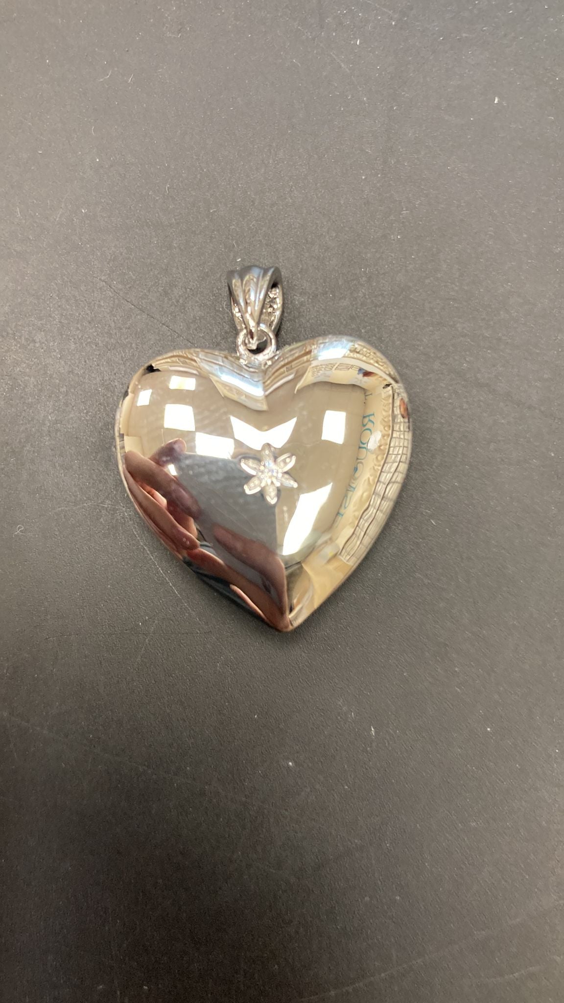 Heart shape sterling silver pendant with a CZ stone in the center, shiny and elegant design.