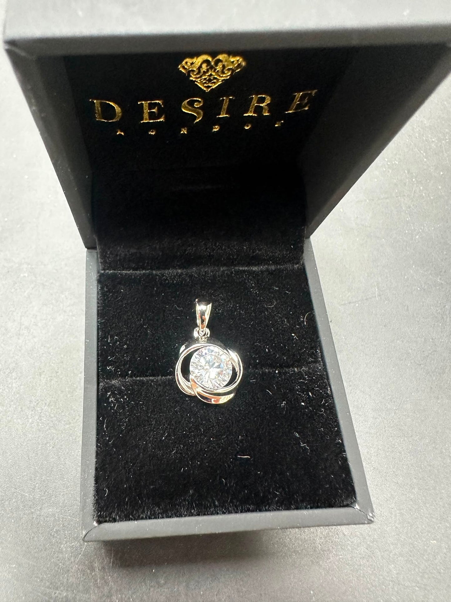 Sterling silver cz pendant displayed in a black jewelry box, featuring a round cz stone.