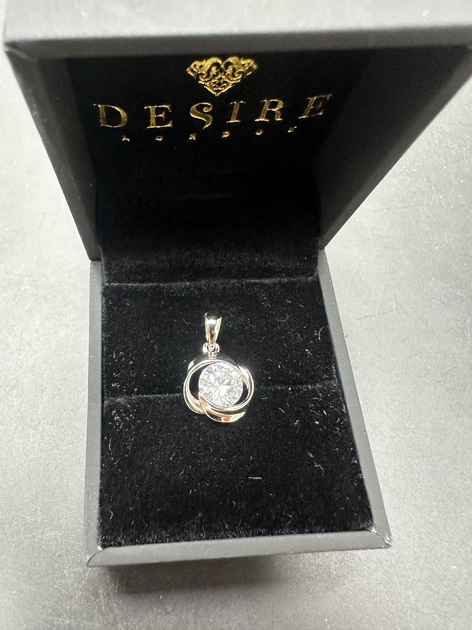 Sterling silver cz pendant displayed in a black jewelry box, featuring a round cz stone.